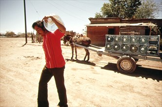 A vendor delivers bottled water from a nearby spring to a home in Mexicali