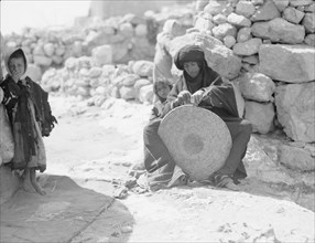 Woman weaving a straw mat. Semi Bedouin type in M'Keis, ancient Gadara (Umm Qais Jordan) ca. 1920