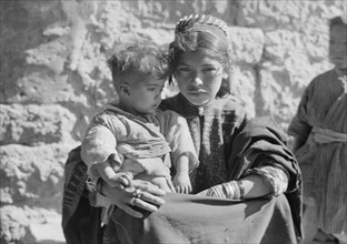 Close up of young Bethlehem woman in the 1930s holding a child ca. between 1934 and 1939