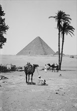 The pyramids of Gizeh,  Great Pyramid of Kheops [i.e., Cheops] and sphinx, men with camels in foreground  ca. 1900