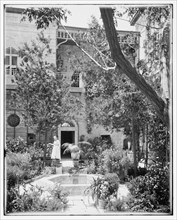 A woman tending the garden in the American Colony courtyard ca. between 1898 and 1923