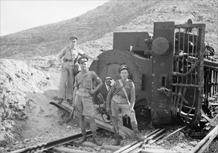 Soldiers stand in front of a wrecked train engine near Deir esh-Sheikh ca. between 1934 and 1939