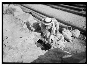 Man looking at ancient aqueducts, the section of Ain Attah aqueduct. Embedded pottery tubes along the Artas road. ca. between 1934 and 1939