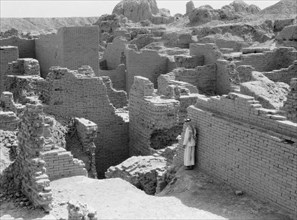 1930s Iraq - Babylon the great. Man standing among the crumbling ruins of Babylon ca. 1932