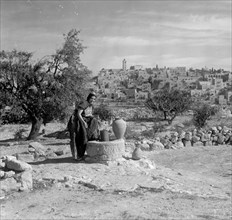 Bethlehem from south with woman at a well clad in richly embroidered costume ca. between 1938 and 1946