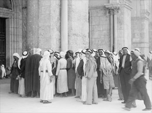 Groups of Arabs in the al-Aqsa Mosque grounds reading rebel posters ca. between 1934 and 1939