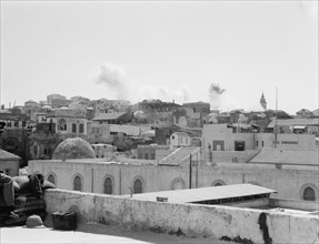 Palestine disturbances during summer 1936 in Jaffa. Troops dynamiting slum section (distant view of smoke in the sky) ca. 1936