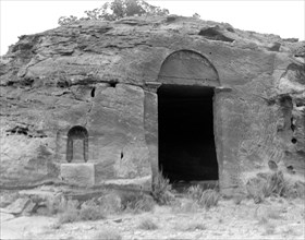 Petra. Wadi-Ed-Der. Doorway near ed-Der. Dushara pillar in niche to left of doorway ca. 1920