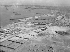 Aerial view of Alexandria Harbour in Egypt, warehouses and railroad station ca. 1932
