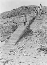Descent from the ziggurat in Ur Iraq. Men walking down a narrow stairway ca. 1932