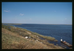 Boat and barge on the Lena River, Farm on shore, view toward Yakutsk from the south, Yakutsk, Russia; 2002