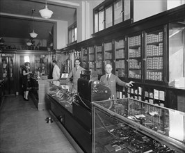 Employees behind display cases at the Offterdinger Cigar Store in Washington DC ca.  between 1910 and 1926
