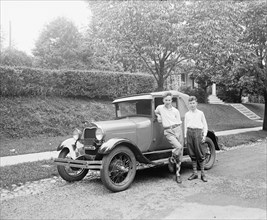 Boys standing next to automobile. ca.  between 1910 and 1920