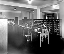 Women working in an office counting or sorting paperwork ca.  between 1910 and 1926