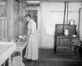 Early 20th century elderly woman working in a kitchen  ca.  between 1910 and 1935