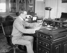 E. Lester Jones reading at his desk  ca.  between 1910 and 1926