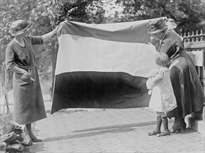 Two suffragettes showing banner to young girl ca. between 1910 and 1930