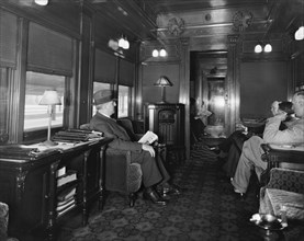 Men speaking, sitting in a train car ca. between 1910 and 1935