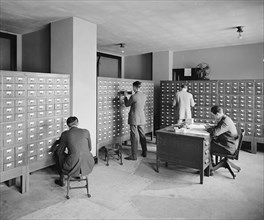 Workers looking at files at the Bureau of Identification ca.  between 1910 and 1926