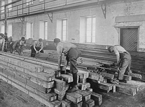 Early 20th century men working with lumber ca.  between 1910 and 1926
