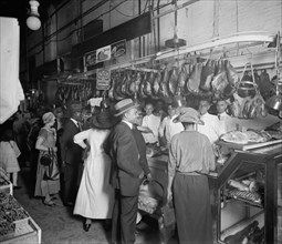 Customers at an early 1900s century meat market  ca.  between 1910 and 1920
