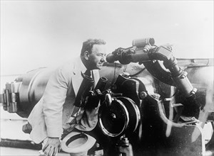 Josephus Daniels on the U.S.S. Wyoming, looking through telescope ca.  between 1910 and 1926
