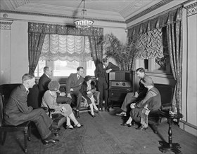 Thomas R. Shipp Company group listening to a radio in a room at the Hamilton Hotel ca. between 1910 and 1935