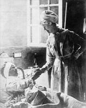 Nurse attending to a patient ca.  between 1910 and 1935
