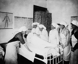 Red Cross nurses attending to a patient ca.  between 1910 and 1935
