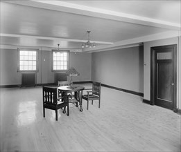 Three chairs and a table inside an otherwise empty room at the Jewish Community Center ca.  between 1910 and 1926