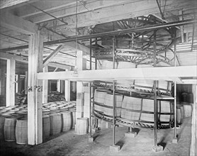 Spiral gravity boiler conveyor for handling barrels and boxes ca.  between 1910 and 1920