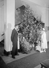 Nurses around Christmas tree with children in wheelchairs ca. between 1910 and 1935