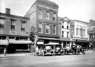 Cars parked outside electrical and atuo supply shops ca.  between 1910 and 1935