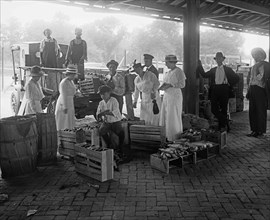 Customers at a market browsing through fruit and vegetables, Washington D.C., World War I period. ca.  between 1910 and 1920