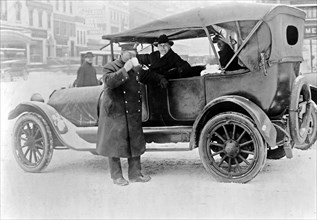 Police officer drinking coffee on a cold day ca.  1910