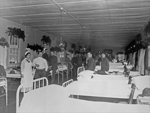 Soldiers and nurse in military hospital, during Christmas season ca.  1910