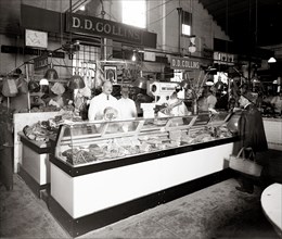 Workers and customers at D.D. Collins' meat stands (Stands 94 and 95) located at O Street Market in the Shaw neighborhood of Washington, D.C. ca.  1915