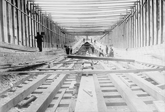 Workers building a wooden ship ca. between 1909 and 1920