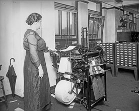 Woman operating a War Risk addressograph machine ca. between 1909 and 1940