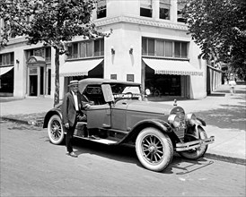 Man standing next to his Ford Motor Company, Lincoln Roadster ca.  between 1910 and 1935