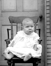 Young baby sitting in a chair  ca. between 1909 and 1919
