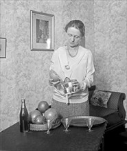 Unidentified woman juicing grapefruit ca. between 1909 and 1932