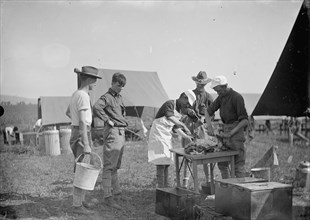 Soldiers cutting meat at a U.S. Army camp kitchen ca. between 1909 and 1940