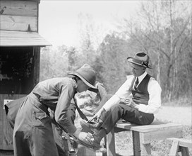 Man receiving a shoe shine ca. between 1909 and 1923