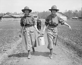 Two women carrying water at a National Women's Defense League camp ca. between 1909 and 1923