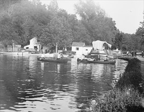 Men rowing canoes in the C&O Canal ca. between 1909 and 1919