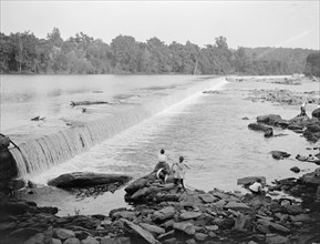 Children playing at the spillway of Great Falls, probably on the Potomoc River ca. between 1909 and 1923