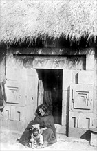 Woman and a child outside a hut in Liahuauacu Boliva ca. between 1909 and 1920