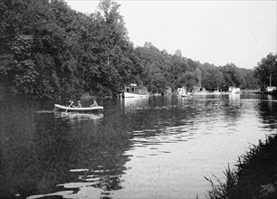 Men rowing a boat in the C&O Canal ca. between 1909 and 1919