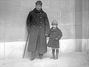 Blind Senator Thomas Schall led by his 6 year old son ca. between 1909 and 1920